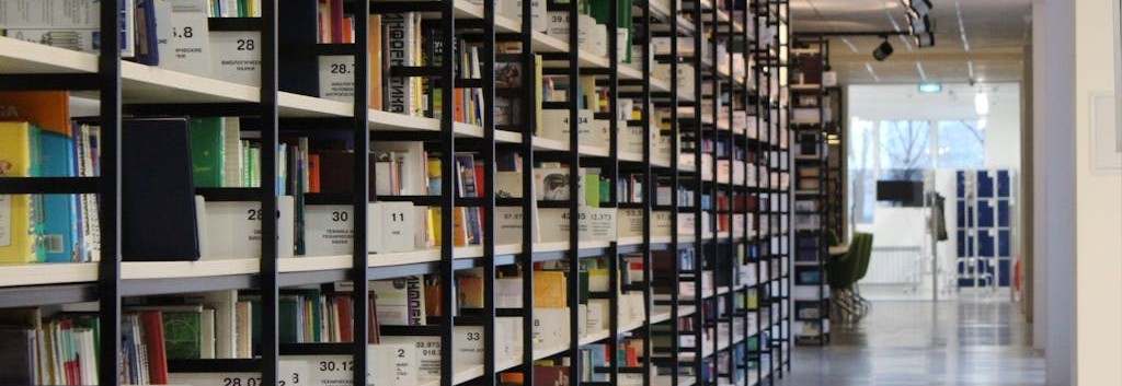 Photo of books on shelves in a library.