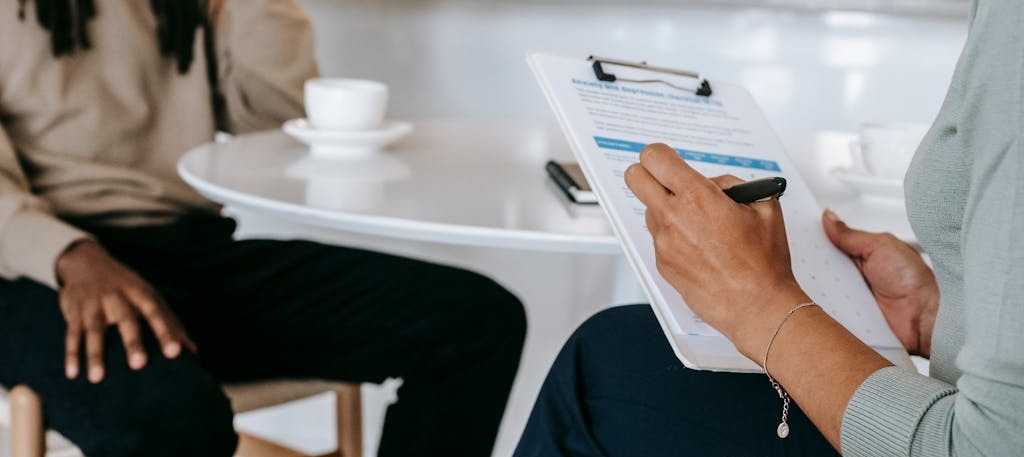 Photo of person holding clipboard, interviewing another person.